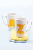 Two white cups printed with the letters A and Z