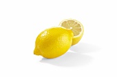 A lemon and a lemon half on a white surface