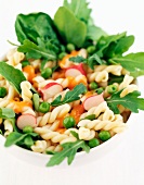 Pasta salad with rocket, radishes and peas