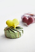 A heart-shaped lime macaroon on top of a present