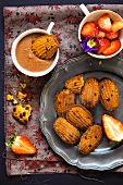 Madeleines with chocolate sauce and strawberries