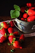 Fresh strawberries in and next to a bucket