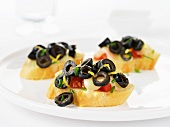 Crostini with black olives, tomatoes and mozzarella