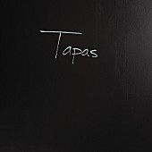The word 'tapas' written on a black surface