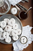 Fried mini doughnuts coated with icing sugar and served with a glass of coffee