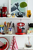 Colourful utensils on white kitchen shelves