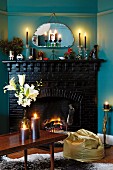 Romantic, candlelit atmosphere with golden beanbag and dark-painted brick fireplace combined with blue-painted walls