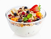 Fruit muesli with yoghurt in a glass bowl