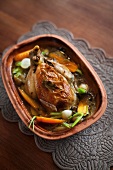 Stuffed chicken with vegetables in a clay pot