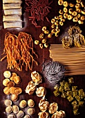 Assorted types of pasta on a wooden board