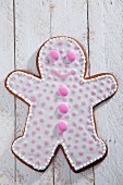 A gingerbread man decorated with pink dots