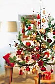 Stylised Christmas tree decorated with various red and gold baubles