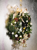 Festively decorated wreath with bow hanging on wall