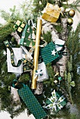 Small gift bags and boxes with Christmas motifs decorating fir branches and logs