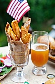 Potato wedges on a table outside, in the background buffalo burgers and a US flag