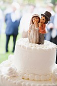A white wedding cake with a sweet decorative bride and groom