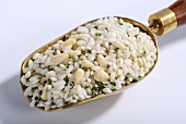 Vialone Nano risotto rice with pine nuts and chives on a brass scoop