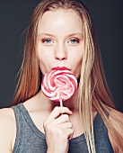 A young woman eating a lollipop