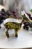 Deer-shaped cookie cutter filled with moss and Aronia berries