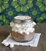 A jar containing dry ingredients for making hot chocolate with marshmallows