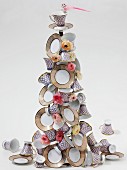 Christmas tree pyramid of patterned china cups and plates decorated with flowers