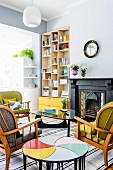 Retro seating area with original side tables; modern bookcase and bright yellow drawers in niche