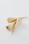 Three parsnips against a white background