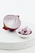 Half a red onion, and pieces of onion in a bowl