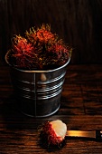 Several rambutans in a small metal bucket