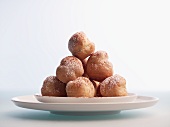 A stack of profiteroles on a plate against a white background
