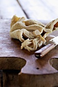 Raw tripe with a knife on a wooden chopping board