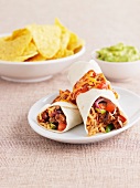 Burritos filled with rice, meat and vegetables
