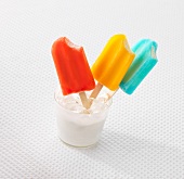 Three ice lollies with colourful coating