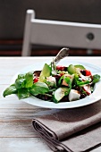 Greek salad with basil, cucumber, tomato, olives and radish