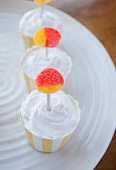 Cupcakes with whipped cream topping and lollipop decoration