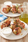 Potatoes wrapped in bacon and cooked on the barbecue, served with a horseradish dip