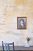 Portrait of child on unpainted wall above wooden table