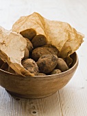 Fresh potatoes on brown paper in a bowl