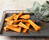 Honey roast parsnips on baking tray with green cloth