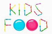 KIDS FOOD written with plastic cutlery and plates