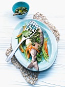 Gilt-head bream with pesto on a bed of vegetables