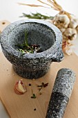 Garlic, herbs and spices in a stone mortar