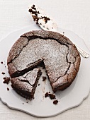 Chocolate cake dusted with icing sugar and sliced