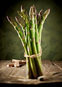 Green asparagus, bunched, on a wooden table