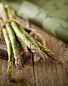 Green asparagus, bunched, on a wooden table