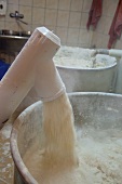 Maschine schüttet Mehl in den Brotteig