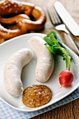 Veal sausages with sweet mustard, radishes and a pretzel (Bavaria)