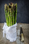 A bunch of green asparagus on a wooden board