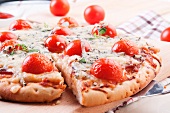 Pizza with blue cheese, ham and cherry tomatoes