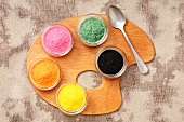 Coloured sugar in small pots on a palette